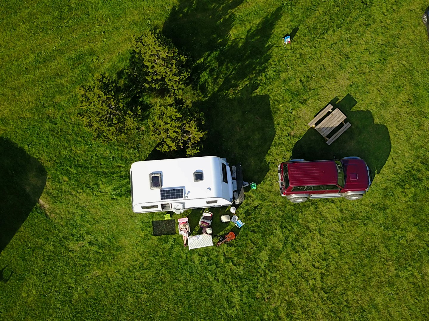 Osoba oddychuje na stoličke pri karavane a SUV.